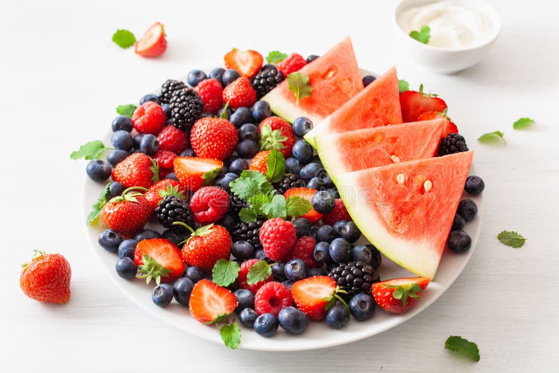 Fruit and berry platter with yogurt over white. blueberry, straw