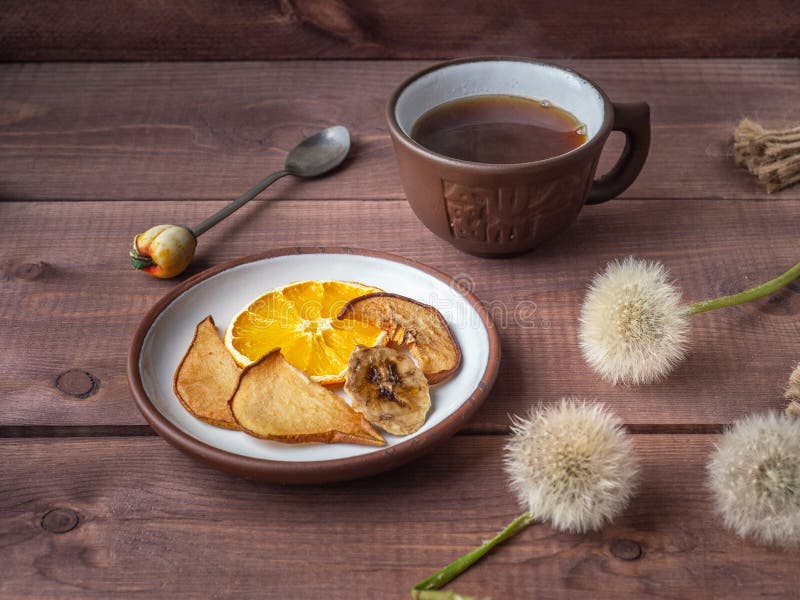 Fruit chips, healthy snack with morning coffee in a brown ceramic mug on a wooden rustic tray stock photos Fruit chips, healthy snack with morning coffee in a brown ceramic mug on a wooden rustic tray stock photos
