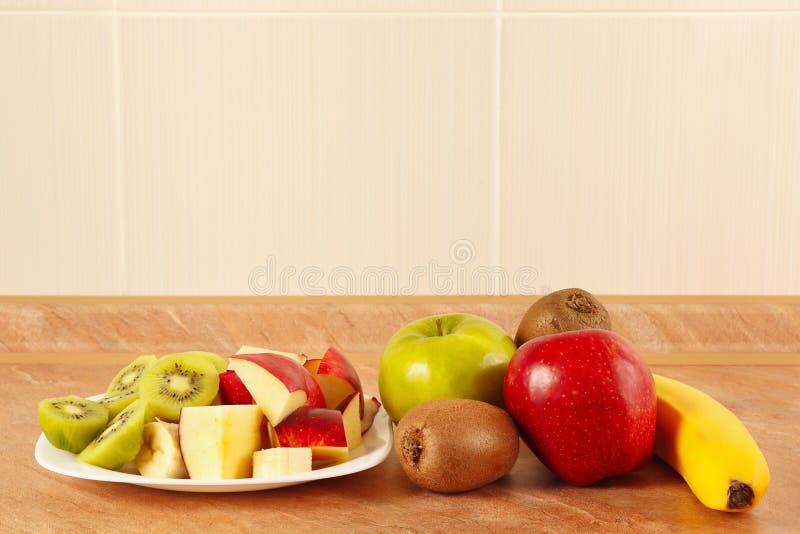 Fruit entier et coupé en tranches frais sur la table de cuisine photo stock Fruit entier et coupé en tranches frais sur la table de cuisine photo stock
