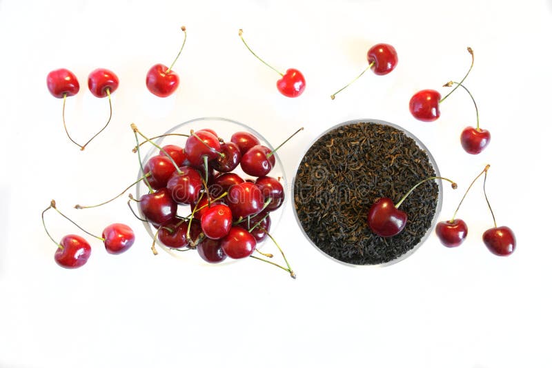 Fruit flavor favorite drink. Traditional black tea next to a red sweet cherry on a white background stock photos Fruit flavor favorite drink. Traditional black tea next to a red sweet cherry on a white background stock photos