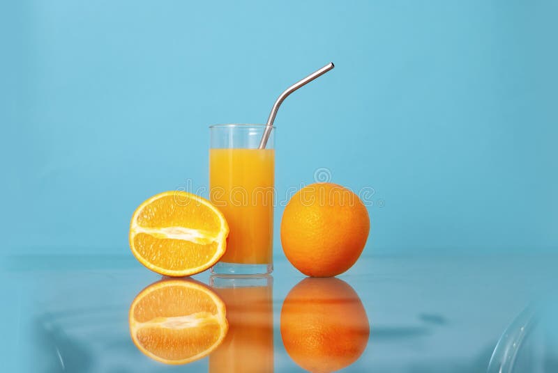 Fruit oranges and orange juice at the glass transparent kitchen table on the light colorful blue background Fresh summer stock photography Fruit oranges and orange juice at the glass transparent kitchen table on the light colorful blue background Fresh summer stock photography