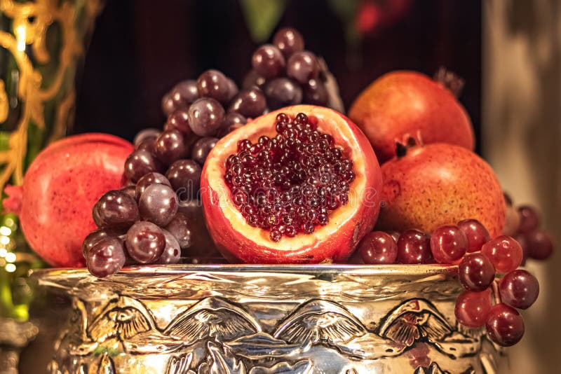 Fruit Pomegranates and Grapes in a Large Metal Vase. New Year`s Table