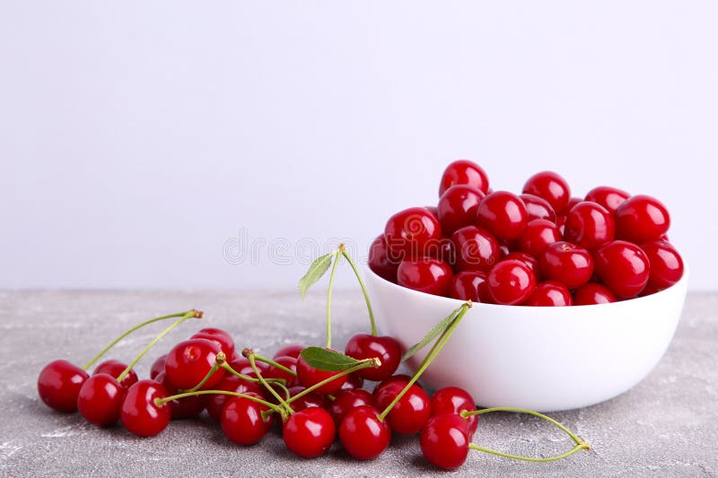 Fruit rouge frais de cerise dans la cuvette sur le fond concret gris photo stock Fruit rouge frais de cerise dans la cuvette sur le fond concret gris photo stock