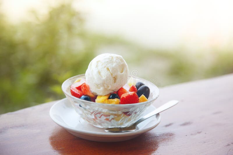 Fruit salad with ice cream on the table outdoors. Horizontal photo with shallow depth of field for natural view. Vibrant colors