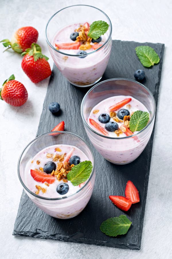 Fruit smoothies met verse bessen, granola en munt royalty-vrije stock afbeelding Fruit smoothies met verse bessen, granola en munt royalty-vrije stock afbeelding