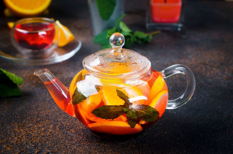 Fruit Tea with orange and lemon Slice, berry, Mint and Honey in teapot. Homemade flavored Fruit Tea with orange and lemon Slice, berry, Mint and Honey in glass