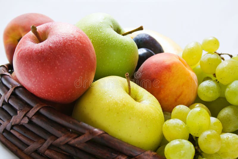 Rôzne čerstvé zrelé plody zblízka umiestnené v prútený kôš.