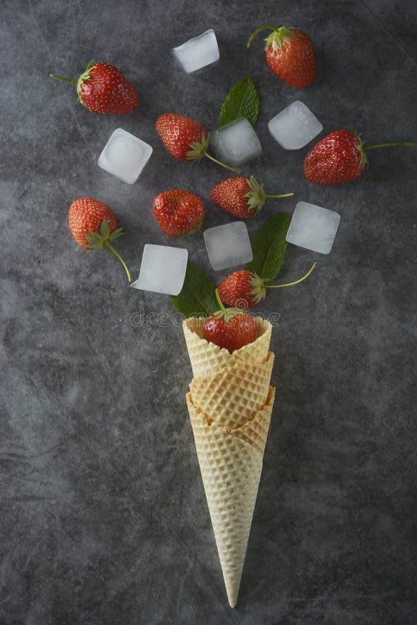 Fruits de fraise dans le cône de gaufre, au-dessus du fond foncé, vue supérieure photo libre de droits Fruits de fraise dans le cône de gaufre, au-dessus du fond foncé, vue supérieure photo libre de droits