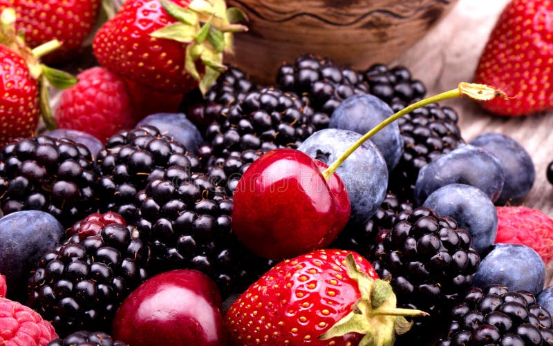 Tasty summer fruits on a wooden table. Cherry, Blue berries, strawberry, raspberries, Blackberries, pomegranate. Tasty summer fruits on a wooden table. Cherry, Blue berries, strawberry, raspberries, Blackberries, pomegranate