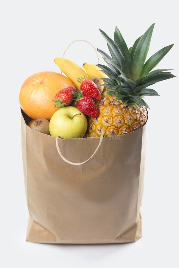 Fruits and vegetables in paper grocery bag isolated over white