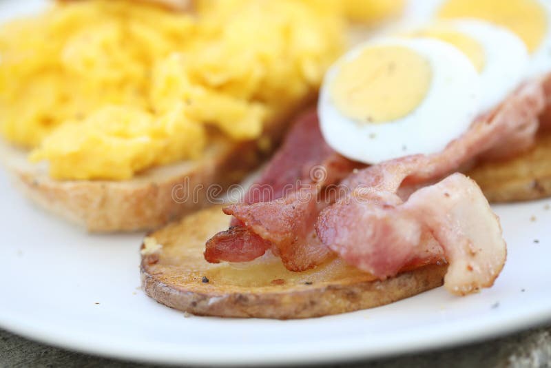 Frukost med förvanskade ägg, stekte potatisar bacon och räka royaltyfri foto Frukost med förvanskade ägg, stekte potatisar bacon och räka royaltyfri foto