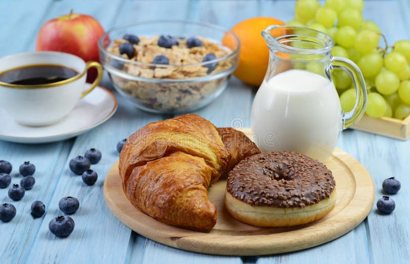 Frukostera med gifflet, munken, kaffe, sädesslag och frukter arkivfoto Frukostera med gifflet, munken, kaffe, sädesslag och frukter arkivfoto