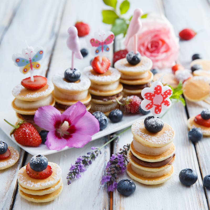 Frukt-, bär- och pannkakacanapes på den vita trätabellen arkivfoto Frukt-, bär- och pannkakacanapes på den vita trätabellen arkivfoto