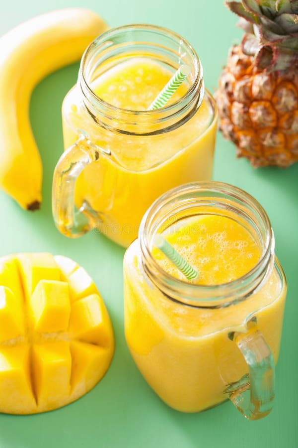 Frullato sano dell'ananas del mango in barattoli di muratore immagine stock Frullato sano dell'ananas del mango in barattoli di muratore immagine stock