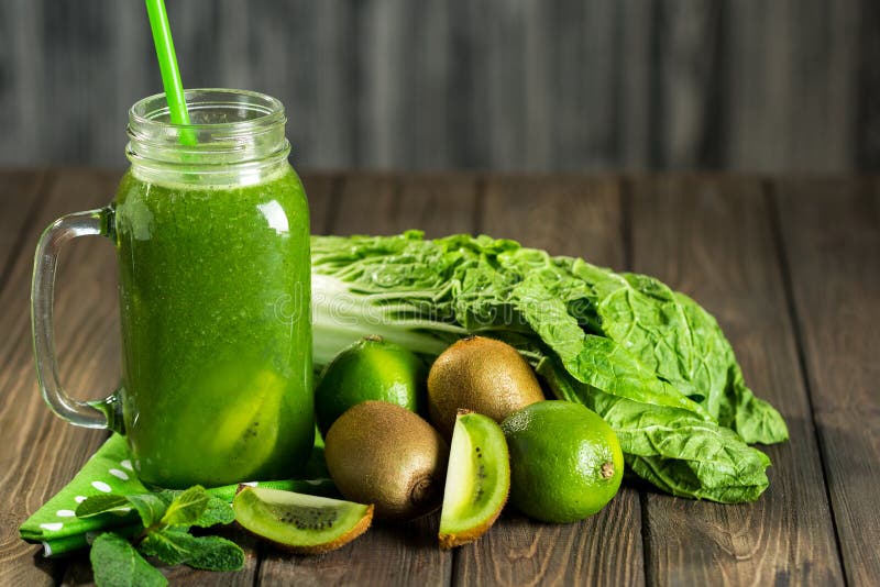 Frullato verde mescolato con gli ingredienti sul selectiv di legno della tavola fotografia stock Frullato verde mescolato con gli ingredienti sul selectiv di legno della tavola fotografia stock