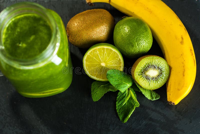 Frullato verde mescolato con gli ingredienti sul tabl di legno di pietra fotografie stock libere da diritti Frullato verde mescolato con gli ingredienti sul tabl di legno di pietra fotografie stock libere da diritti