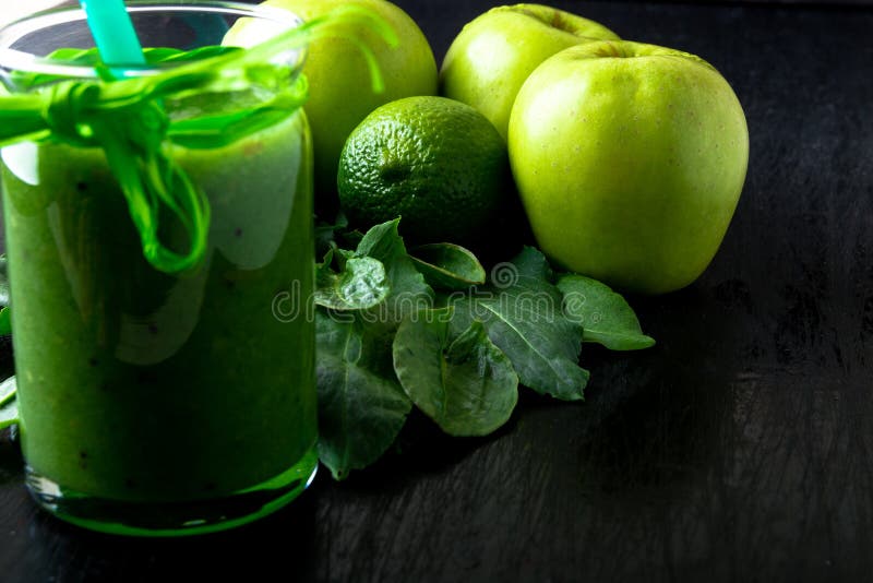 Frullato verde vicino agli ingredienti per su fondo di legno nero Apple, calce, spinaci detox Bevanda sana Alimento puro immagine stock Frullato verde vicino agli ingredienti per su fondo di legno nero Apple, calce, spinaci detox Bevanda sana Alimento puro immagine stock