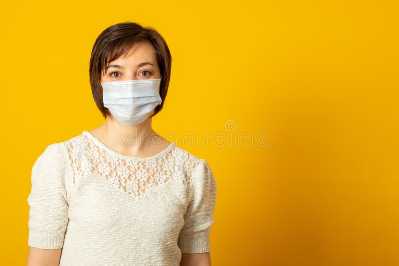 Frumoasă doamnă brunetă are o epidemie care poartă mască medicală de protecție și infecția stă în interior. asistență medicală și royalty free stock photography