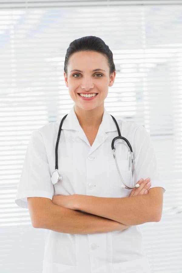 Frumoasă femeie doctor zâmbitoare cu brațe încrucișate royalty free stock image
