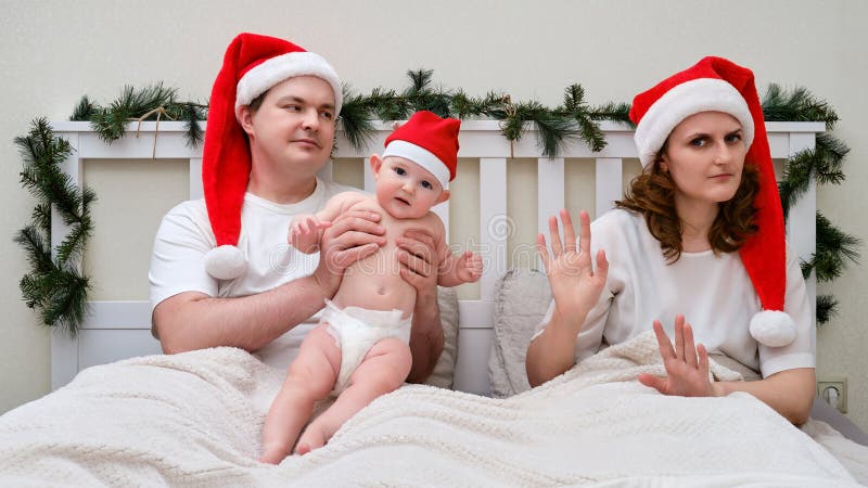 Frun vägrar att ta hand om barn på sängen som dekorerats för julklappar och en royaltyfri foto