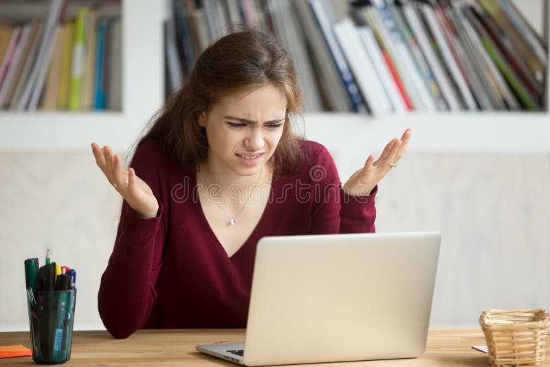 Frustrated annoyed woman confused by computer problem looking at