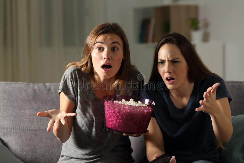 Frustrated friends watching tv in the night stock photography Frustrated friends watching tv in the night stock photography