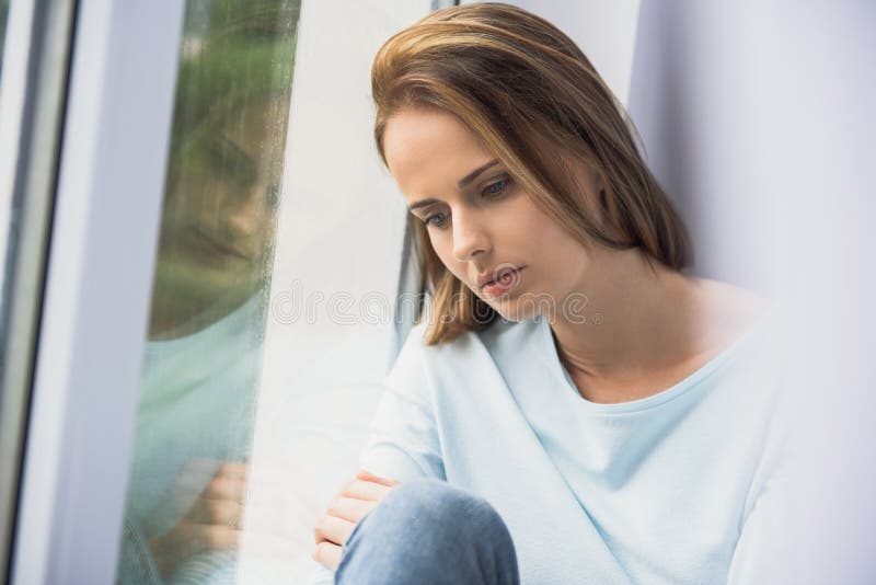 Frustrated girl sitting by the window
