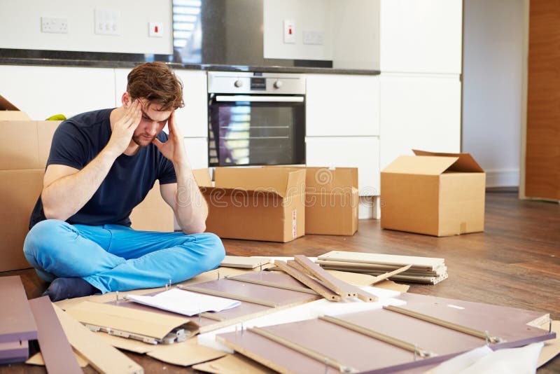 Frustrated Man Putting Together Self Assembly Furniture royalty free stock photography Frustrated Man Putting Together Self Assembly Furniture royalty free stock photography