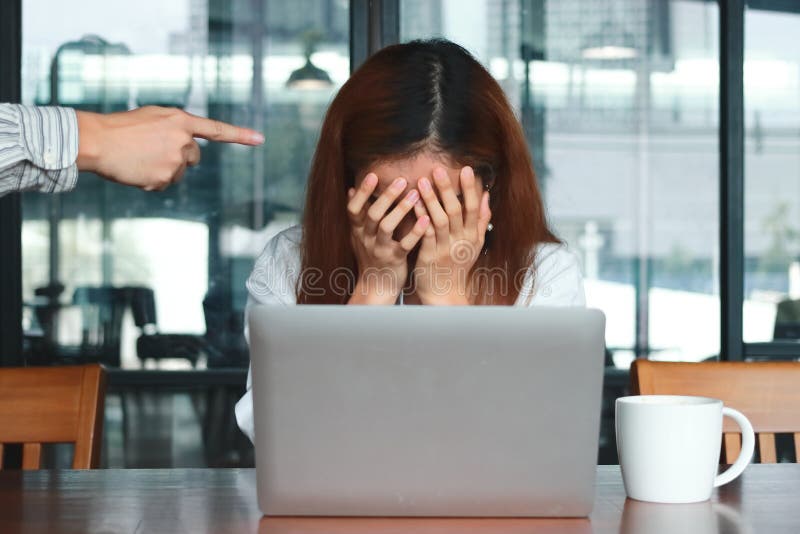 Frustrated stressed young Asian business with covering is being pointed hand`s boss in workplace.