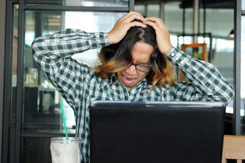 Frustrated stressed young Asian man in casual clothes feeling stress in office. stock image Frustrated stressed young Asian man in casual clothes feeling stress in office. stock image