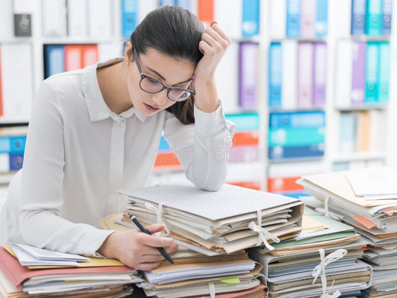 Sad young office worker overloaded with work