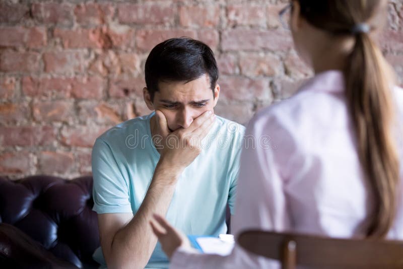 Frustrated young man at a reception with psychologist. royalty free stock photos
