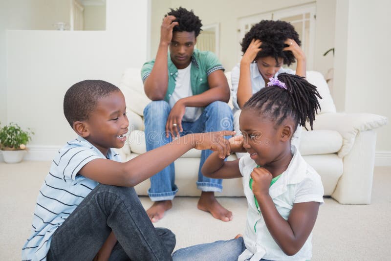 Frustrierte Eltern, die ihren Kinderkampf aufpassen stockfotografie
