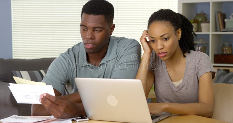 Frustrierte junge schwarze Paare, die online über Rechnungen und Finanzen hinausgehen lizenzfreie stockfotografie Frustrierte junge schwarze Paare, die online über Rechnungen und Finanzen hinausgehen lizenzfreie stockfotografie