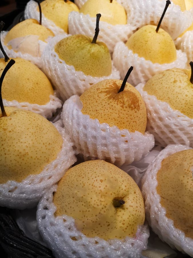 Fruta china de la pera envuelta en amortiguar de la espuma disponible en estantes en supermercados foto de archivo libre de regalías Fruta china de la pera envuelta en amortiguar de la espuma disponible en estantes en supermercados foto de archivo libre de regalías