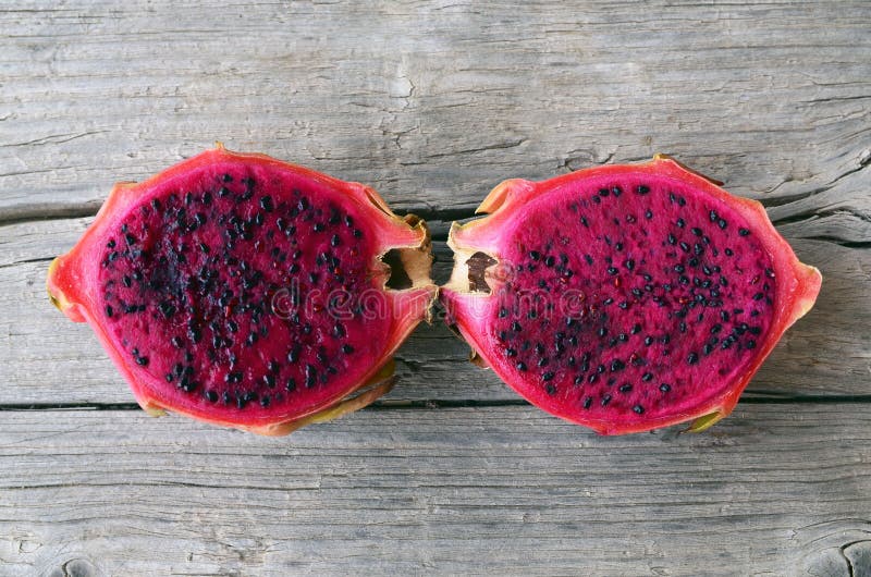 Fruta rosada madura exótica de Pitaya o del dragón La fruta tropical roja de Pitahaya cortó por la mitad en la tabla de madera vi fotografía de archivo Fruta rosada madura exótica de Pitaya o del dragón La fruta tropical roja de Pitahaya cortó por la mitad en la tabla de madera vi fotografía de archivo