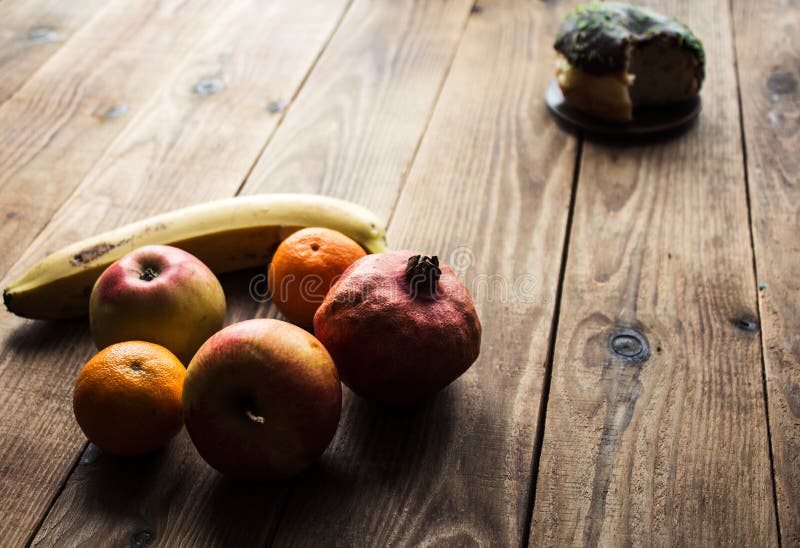 Fruta y buñuelo con el chocolate en un fondo de madera foto de archivo libre de regalías Fruta y buñuelo con el chocolate en un fondo de madera foto de archivo libre de regalías