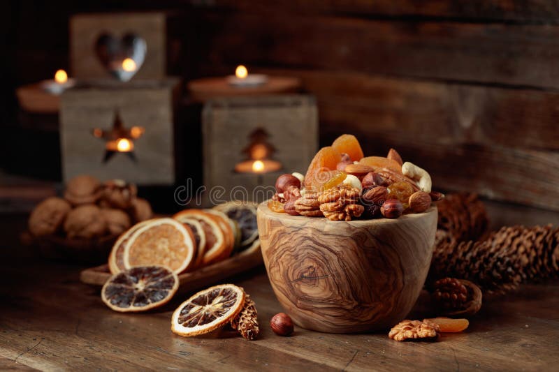 Frutas secas y nueces variadas sobre una mesa de madera. Frutos secos y nueces variadas sobre una mesa de madera antigua. quietud de navidad con velas en llamas. espacio de copia
