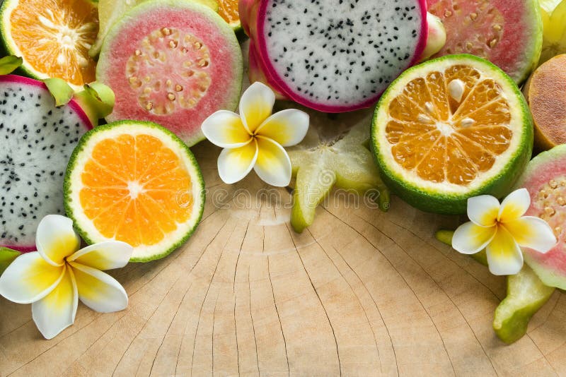Frutas tropicales mandarina, guayaba, fruta del dragón, fruta de estrella, zapote con las flores del plumeria en el fondo de made fotos de archivo libres de regalías Frutas tropicales mandarina, guayaba, fruta del dragón, fruta de estrella, zapote con las flores del plumeria en el fondo de made fotos de archivo libres de regalías