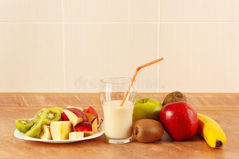 Fruto fresco e um vidro da agitação de leite na mesa de cozinha fotografia de stock royalty free Fruto fresco e um vidro da agitação de leite na mesa de cozinha fotografia de stock royalty free