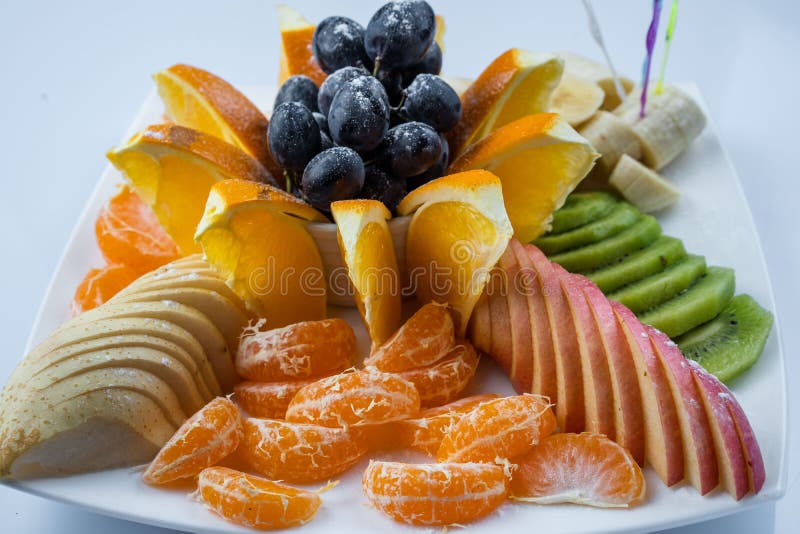 Frutta mista in piatto bianco su fondo bianco - stile sano dell'alimento immagini stock Frutta mista in piatto bianco su fondo bianco - stile sano dell'alimento immagini stock