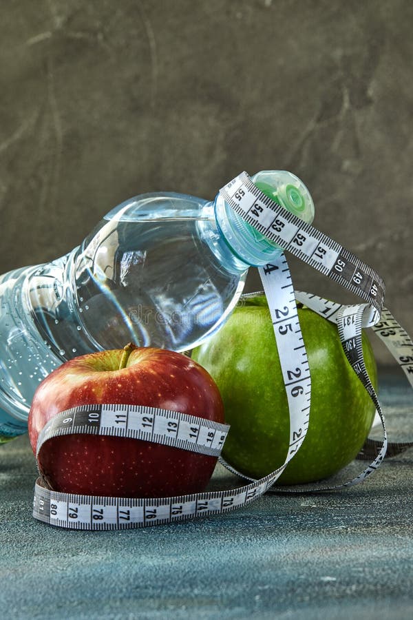 Frutta, una bottiglia di acqua, un metro su un blu con un fondo di divorzio fotografia stock Frutta, una bottiglia di acqua, un metro su un blu con un fondo di divorzio fotografia stock