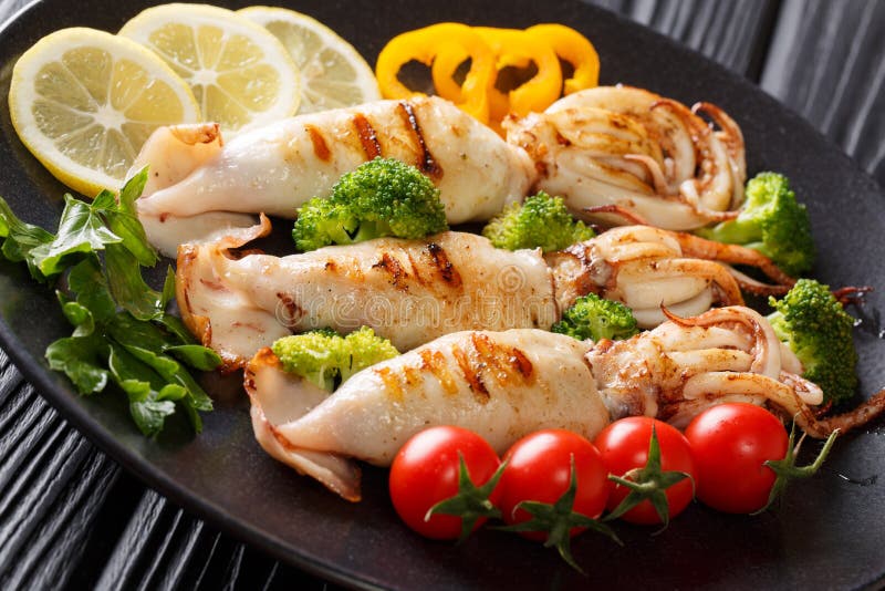 Frutti di mare sani dell'alimento: il calamaro arrostito con gli ortaggi freschi si chiude fotografie stock Frutti di mare sani dell'alimento: il calamaro arrostito con gli ortaggi freschi si chiude fotografie stock