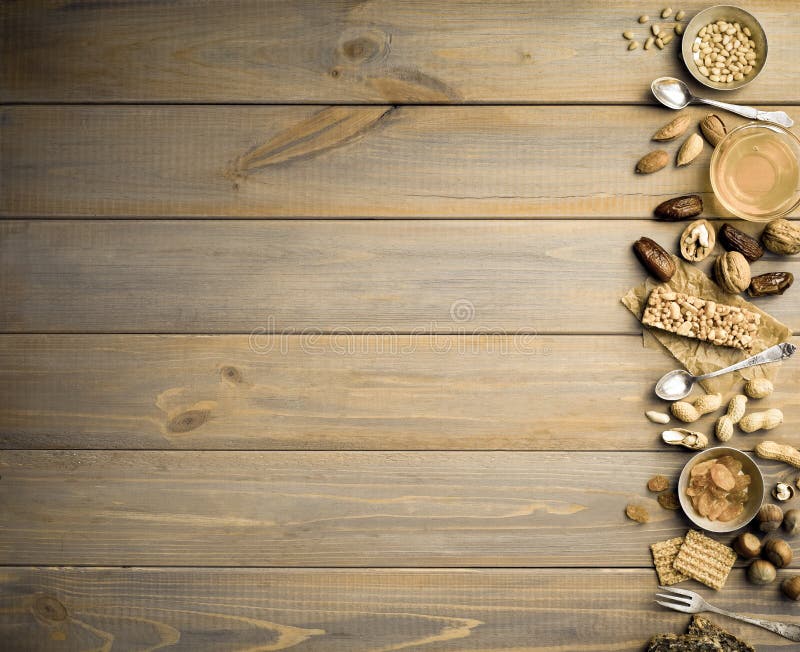 Frutti matti e secchi, miele e vecchi cucchiai e forchette su un fondo di legno della tavola immagini stock libere da diritti Frutti matti e secchi, miele e vecchi cucchiai e forchette su un fondo di legno della tavola immagini stock libere da diritti