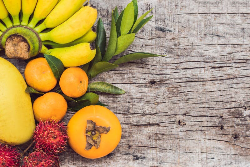 Frutti variopinti sulla tavola di legno bianca, banane, carambola, mango, papaia, mandarino, rambutan, Pamela, spazio della copia immagini stock libere da diritti Frutti variopinti sulla tavola di legno bianca, banane, carambola, mango, papaia, mandarino, rambutan, Pamela, spazio della copia immagini stock libere da diritti