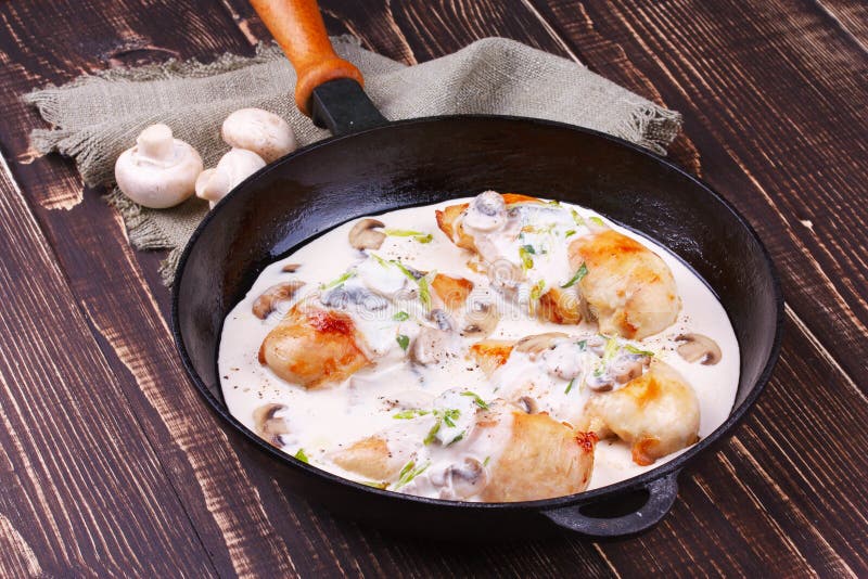 Frying Pan with Fried Chicken Breast, Mushrooms and Greens. Stock Photo