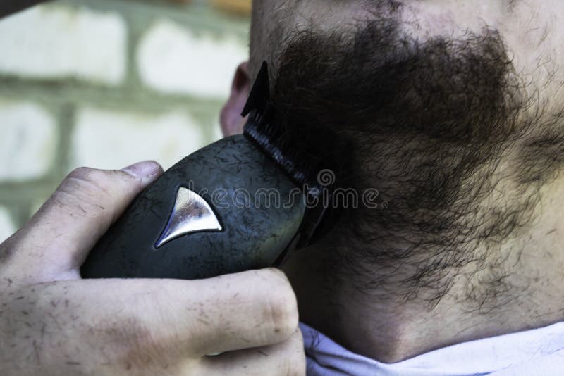 Fryzjer męski ciie jego brodę facet z shearing maszyną obraz stock Fryzjer męski ciie jego brodę facet z shearing maszyną obraz stock