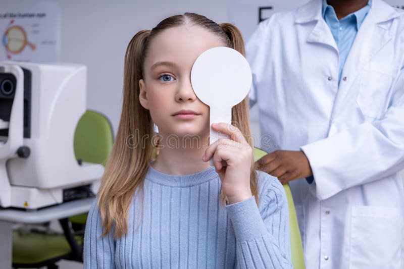 Fryzjerskie kaukaskie dziecko, które przeprowadziło badanie okulistyczne w biurze optometrist obrazy royalty free
