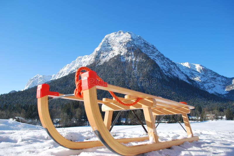 A sled in front of a snow covered mountain. A sled in front of a snow covered mountain.