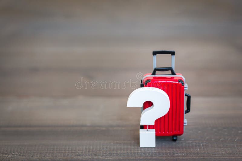 Frågetecken med Red Luggage Bag på träbord , problemkoncept fotografering för bildbyråer Frågetecken med Red Luggage Bag på träbord , problemkoncept fotografering för bildbyråer